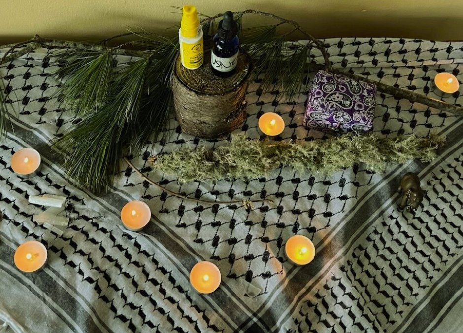 Lit tea candles on a black and white Keffiyeh making a shrine.